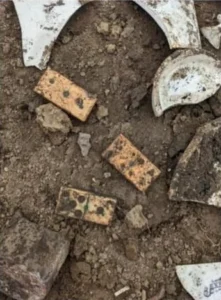 Three bone, wood, and copper alloy dominoes.